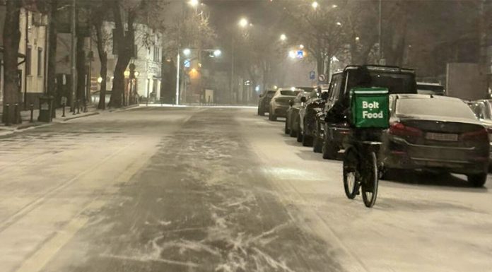 Cum a fost fotografiat acest livrator nepalez noaptea, în timp ce ningea în București. Reacția unei șoferițe