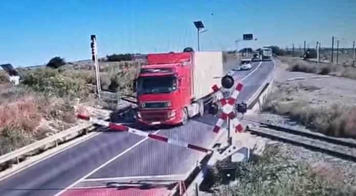 Momentul în care un șofer de TIR trece peste bariera de cale ferată, în Constanța. Circulaţia feroviară a fost afectată