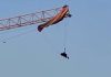 Un parapantist a rămas suspendat la 60 de metri după ce parașuta sa s-a încurcat într-o macara, în China. VIDEO