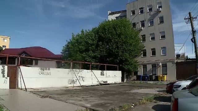 Un bărbat din Craiova a blocat un bloc întreg cu un gard. Oamenii trec printr-un magazin ca să ajungă acasă